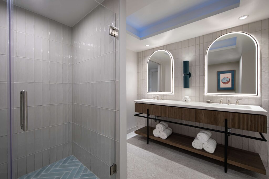 Modern bathroom with walk-in shower and mirrors.