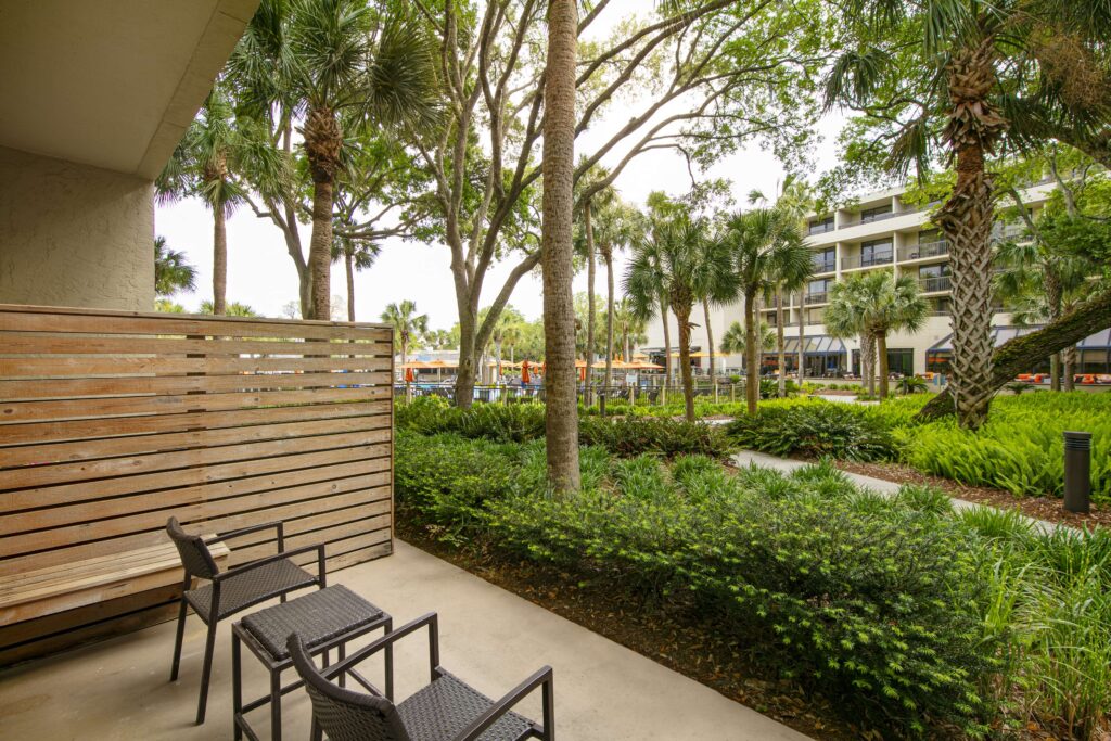 Patio seating with lush greenery and privacy wall.