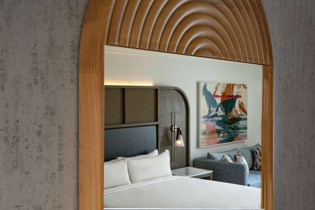 Room view through a decorative mirror, showcasing a bed and a sofa.