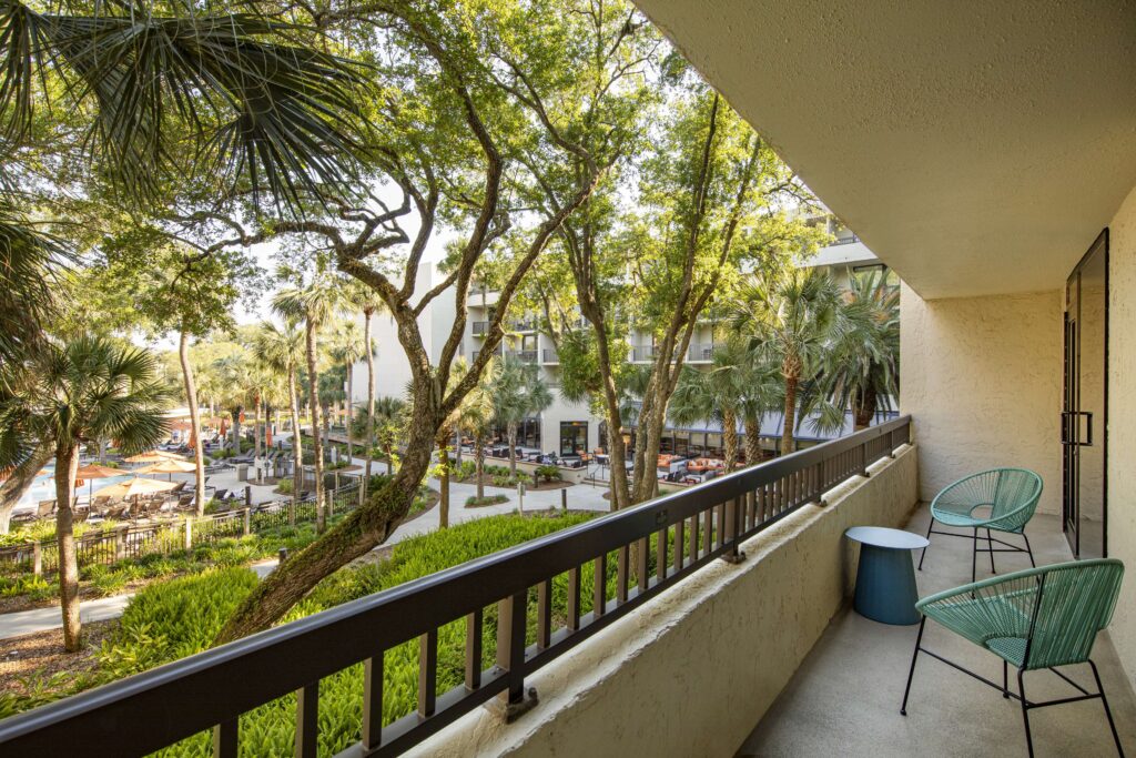 Balcony with seating overlooking lush greenery.