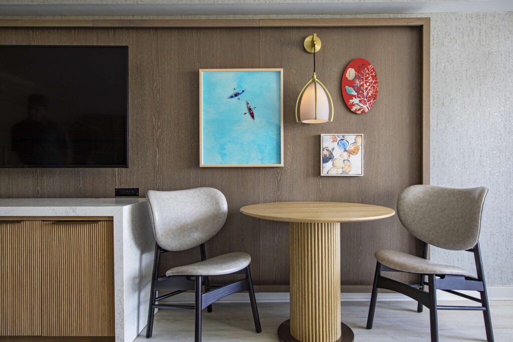 Small dining nook with art pieces and a mounted television.