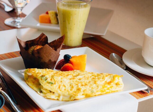 Healthy breakfast with omelette, fruit, and smoothie.