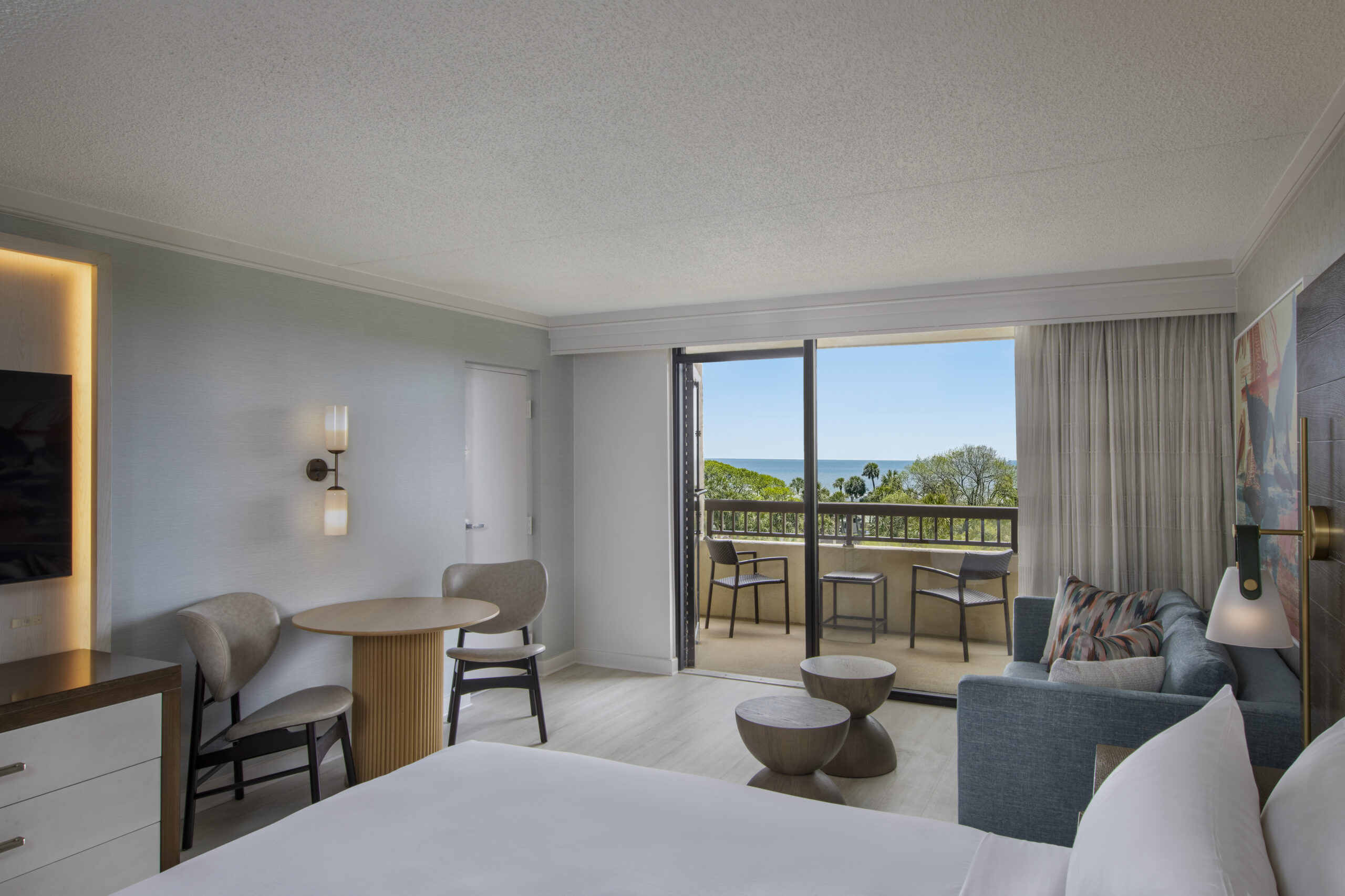 Hotel room with balcony offering ocean views.