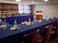 Conference setup with long tables and blue tablecloths.