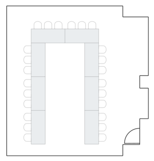 Long room layout with rows of rectangular tables.