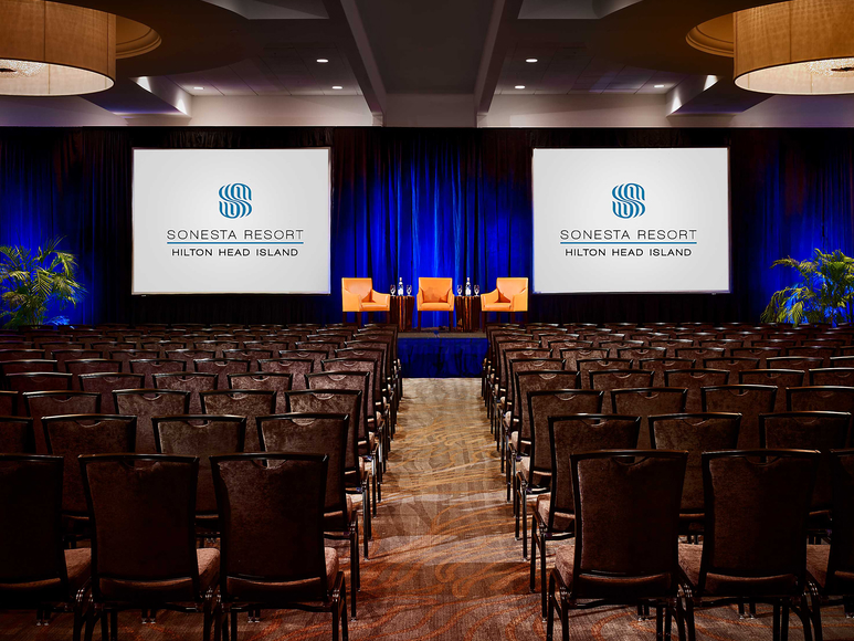 Conference setup with screens and chairs.