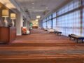 Hotel corridor with seating area and wooden floor.